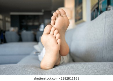 Close up of boy foot lying on floor at home - Shutterstock ID 2282811161