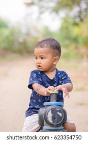 close up boy playing on the motorcycle in the park . child driving motorcycle toy,happiness boy with toy , sad boy , crying boy with copy space