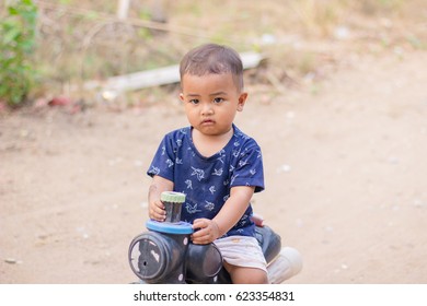close up boy playing on the motorcycle in the park . child driving motorcycle toy,happiness boy with toy , sad boy , crying boy