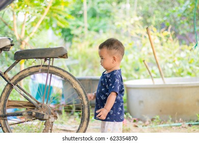 close up boy playing on the motorcycle in the park . child driving motorcycle toy,happiness boy with toy , sad boy , crying boy with copy space