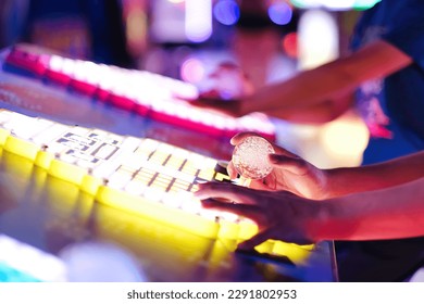 Close up of boys operating,  controlling joystick and playing classic retro arcade video games at amusement park. - Powered by Shutterstock