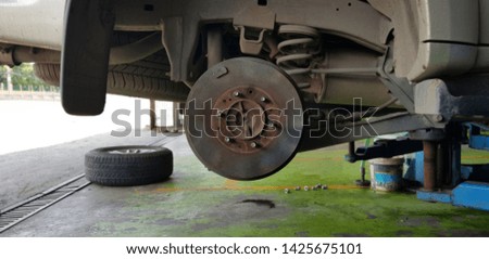 Close up of Brake Disc of the vehicle for repair,Automobile mechanic in process of new tire replacement,Car brake repairing in garage.