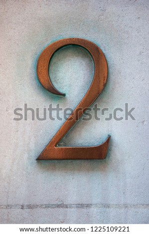 A Close Up of a Brass Number Two Door Number on a Wall