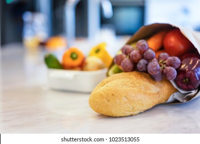 Close up bread and colorful fresh vegetables and fruits with a bag of groceries shopping in the kitchen.Healthy eating concept