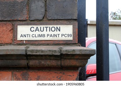 Close Up of Brick Wall with 'Caution' Sign 