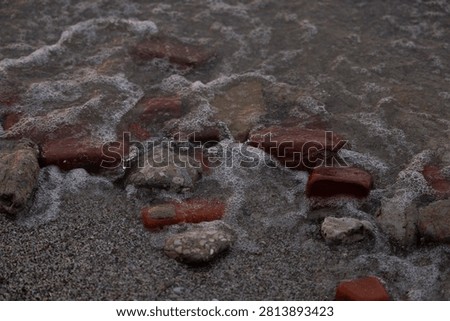 Close Up of Bricks and Rocks on the Beach 