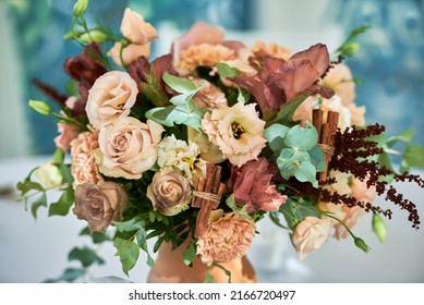Close up of bridal bouquet of roses and greenery in vase on table outdoors, copy space. Wedding concept