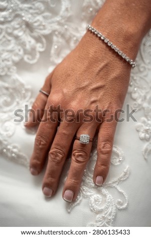Close up of bride wearing diamond ring and bracelet.