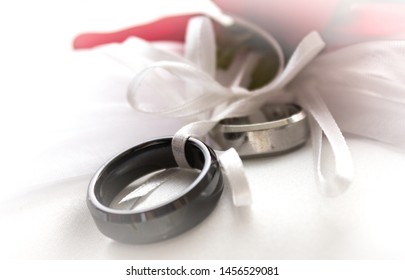 Close Up Of Brides White Lace Gown And Grooms  Red Rcmp Uniform Displaying Rings With A Light And Airy Background After The Wedding Ceremony