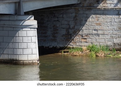 Close Up To A Bridge Pillar In The River That Flows Under