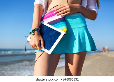 Close up bright details, geek woman holding tablet on her hands, posing near beach ocean, vacation freelance mood. - Shutterstock ID 698086531