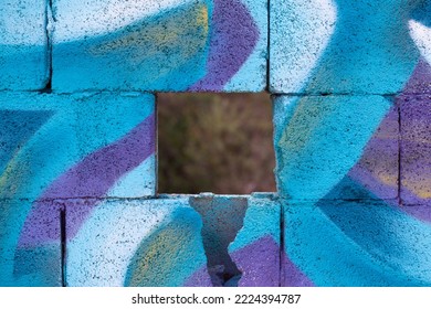Close up of brightly colored spray paint graffiti on textured breeze block wall