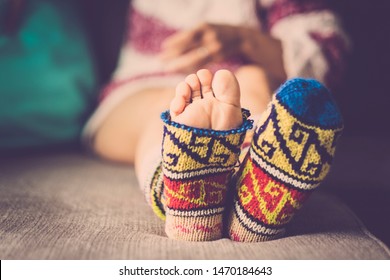 Close Up Of Broken Funny Warm Winter Socks With Feet Outside - Nice Woman Sitting On The Sofa At Home