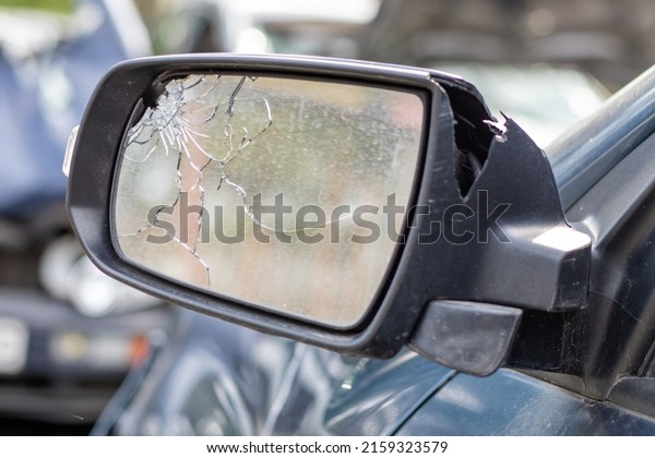 Close\
up broken left side rearview mirror of a car in blue. Auto\
insurance concept. Broken side glass of the car on the driver\'s\
side as a result of an accident. Criminal\
incident