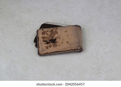 Close Up Of Broken Wallet On White Floor Background.