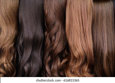 Close up brown and another color of hair wigs display in beauty salon.