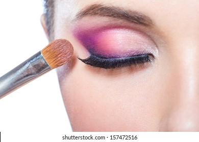 Close Up Of Brush Applying Bright Pink Makeup On Eye Of Pretty Girl, Isolated On White