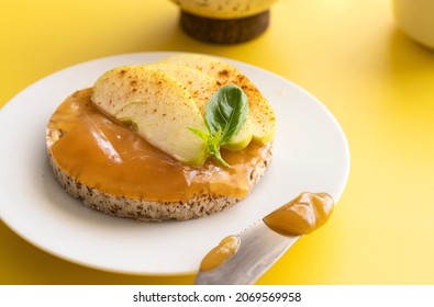 Close Up Buckwheat And Rice Snack With Almond Butter And Apple Decorated With Cinnamon And Basil On Yellow Background,  