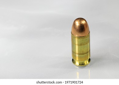 Close up of bullet 11 mm or .45 acp FMJ (Full Metal Jacket ) ready for use, isolate on white background reflection surface.