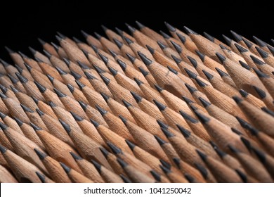 Close Up of bunch of identical sharp graphite pencils on black background. Studio shot. Concept of uniformity. Concept of similarity.