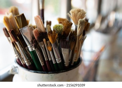 Close up bunch of used and cleaned diverse shapes and size, natural bristle paintbrushes in bucket, tools, supplies for artists after art-class. Creative hobby, painter equipment background concept - Powered by Shutterstock