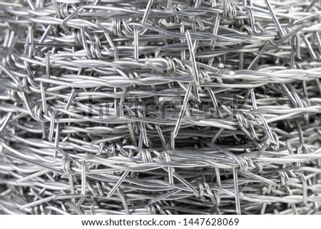 Close up A bundle of Galvanized Barbed Wire or Barb Wire Fencing with sharp edges isolated on white background.

