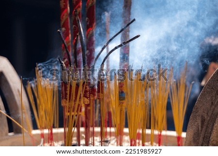 Close up of burning incense sticks on the doors of temples in Vietnam. Burning incense sticks inside a large metal container. Religion concept.