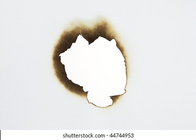 Close Up Of Burnt Paper Hole On White Background