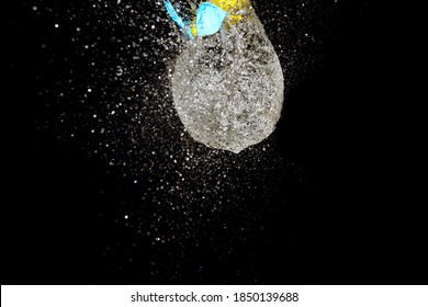 Close Up Of Burst Water Balloon On Black Background