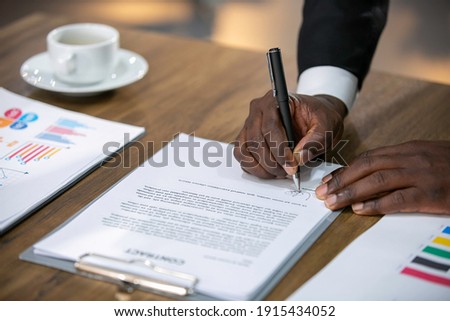 Close up business African American businessman signing contract or MOU making a deal, classic business contract or mutual agreement.