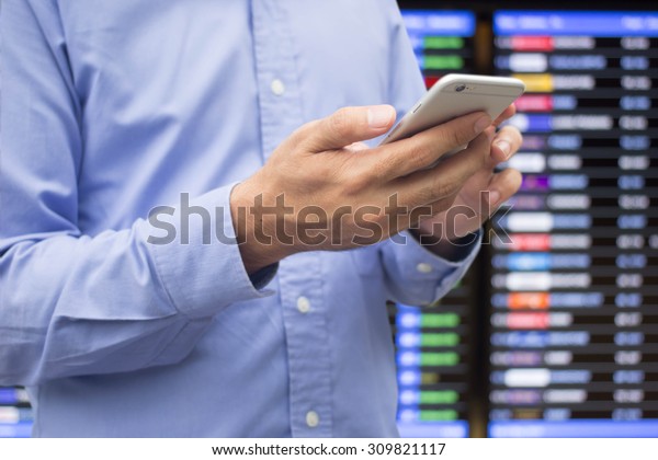 close up business man\
checking market price by smart phone mobile device over blurred\
stock trade board