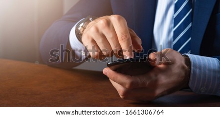 close up business man hand hold and pressing smartphone formal s