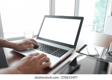 Close Up Of Business Man Hand Working On Blank Screen Laptop Computer On Wooden Desk As Concept