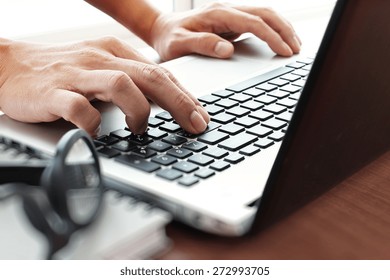 Close Up Of Business Man Hand Working On Blank Screen Laptop Computer On Wooden Desk As Concept