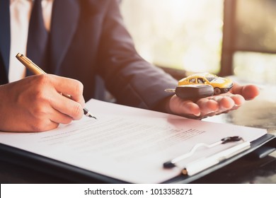 Close up business man reaching out sheet with contract agreement proposing to sign.Insurance agent and insurance company customers.Concept of insurance with house and car 