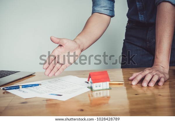 Close up business man reaching out sheet with contract
agreement proposing to sign.Insurance agent and insurance company
customers.Concept of insurance with house and car

