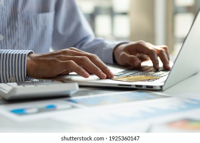 Close up Business man using calculator and laptop for do math finance on wooden desk, tax, accounting, statistics and analytical research concept