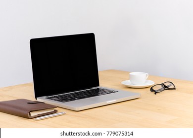 Close Up Of Business Office Desk With Pen Board Coffee In Front Of Empty White Brick Textured Wall Background.