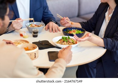 Close Up Of Business People Enjoying Asian Food During Business Lunch In Cafe