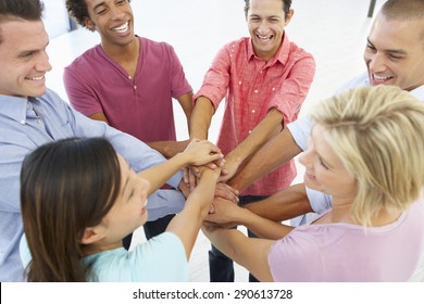 Close Up Of Business People Joining Hands In Team Building Exercise