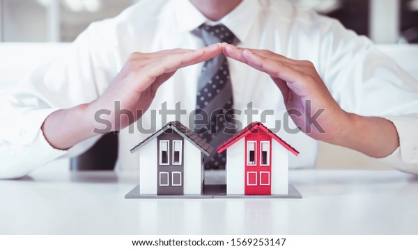 Close up of business person\
hand protect small house signing contract,have a contract in place\
to protect it,signing of modest agreements form In\
office\
\
