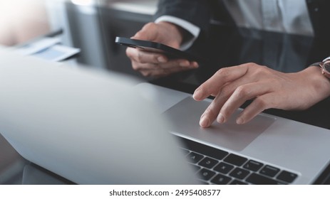 Close up of business woman hand working on laptop computer and using mobile smart phone on office table, connecting the internet, search digital content. Business and technology concept - Powered by Shutterstock