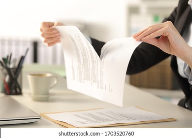 Close up of business woman hands breaking contract document sitting on a desk at the office