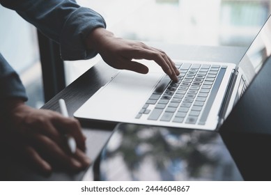 Close up of business woman hands typing on laptop computer and digital tablet, searching and surfing the internet on office desk, online working, telecommuting, freelancer at work concept - Powered by Shutterstock