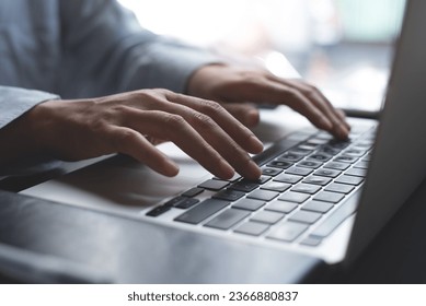 Close up of business woman hands working, typing on laptop computer keyboard, surfing the internet on office desk, online working, telecommuting, freelancer at work concept