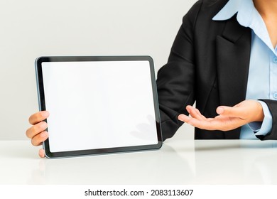Close up of business woman showing blank tablet screen.
