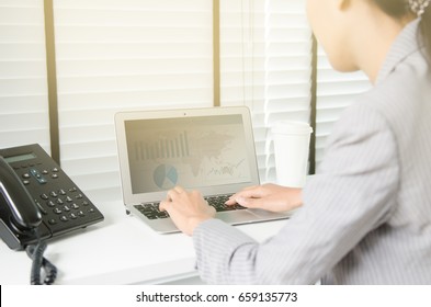 Close up business woman working in office with business graph on computer