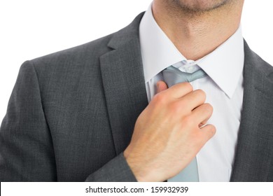 Close up of businessman adjusting tie on white background