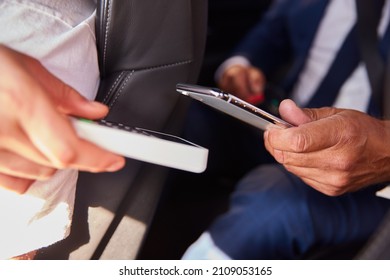 Close Up Of Businessman In Back Of Taxi Paying Fare Using Contactless Payment App On Mobile Phone - Shutterstock ID 2109053165
