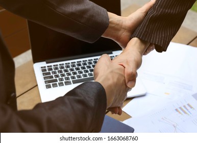 Close up of Businessman with client shake hand and holding hands together for comfort and support work together, insurance team,respect and trust concept - Shutterstock ID 1663068760